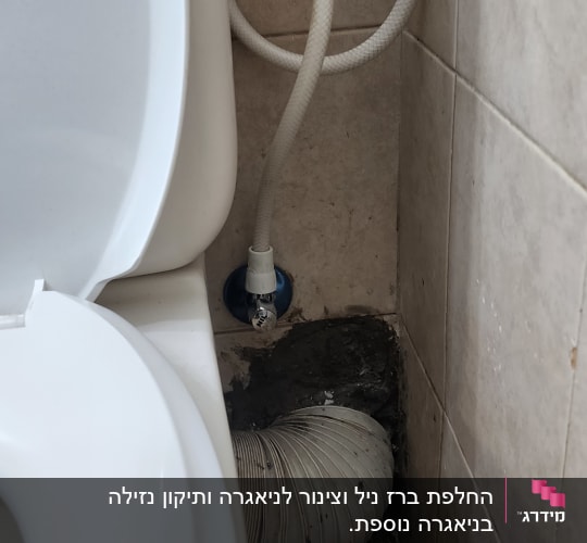 אסלה עם צינור ניקוז גמיש וצינור מים מחובר